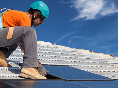 Guy putting in new solar panels on roof